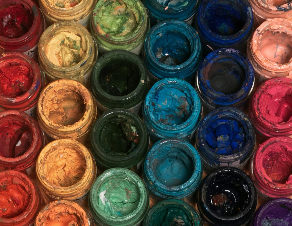 Rows of open and used paint containers.
