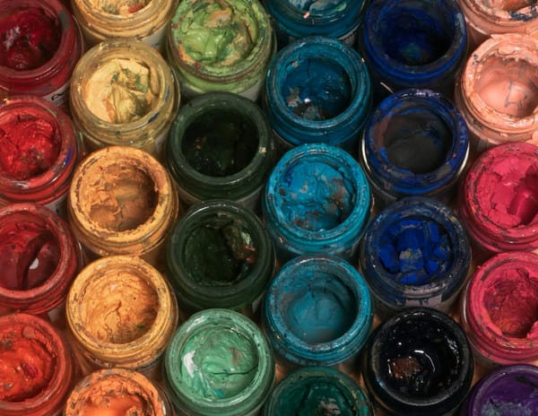 Rows of open and used paint containers.